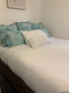 1 cama grande con sábanas blancas y almohadas azules en Family Getaway en Perth