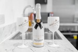 een fles wijn in twee wijnglazen op een aanrecht bij Modern Apartment in Brierley Hill - Secure Parking - Wifi & Netflix - 11O in Brierley Hill