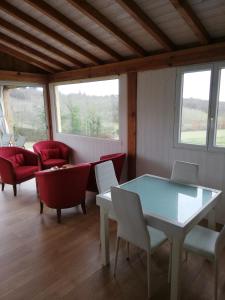 Habitación con mesa, sillas y ventanas. en La Quercynoise, en Le Vigan