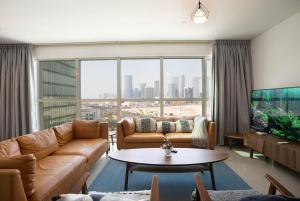 a living room with a couch and a large window at Exquisite Apartment Rak in Abu Dhabi