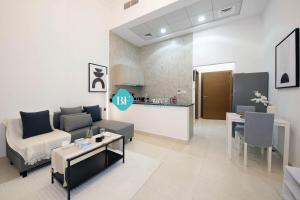 un soggiorno con divano e tavolo di Spacious Studio Apartment a Abu Dhabi