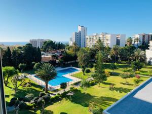 einen Luftblick auf ein Resort mit einem Pool und Palmen in der Unterkunft Apartamento en urbanización con fantásticas vistas in Benalmádena