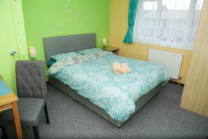 ein Schlafzimmer mit einem Bett mit zwei Schuhen drauf in der Unterkunft Lux House in Peterborough