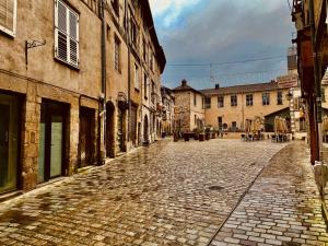 a cobblestone street in an old town with buildings at La suite de L'Evêché in Limoges
