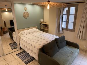 a bedroom with a bed and a couch and a mirror at La suite de L'Evêché in Limoges