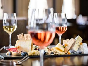 基督城的住宿－諾富特基督城大教堂廣場酒店，一张桌子,上面放着两杯葡萄酒和奶酪