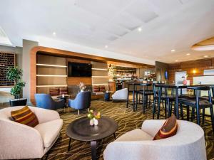 a lobby with couches and a bar in a hotel at Novotel Christchurch Cathedral Square in Christchurch
