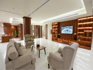 a living room with couches and a flat screen tv at Hams Park Hotel in Jeddah