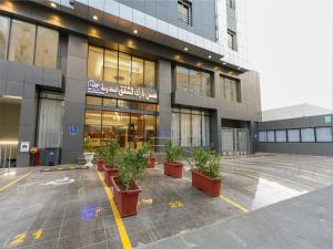 فندق همس بارك  في جدة: مبنى به نباتات الفخار في موقف للسيارات