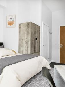 Dormitorio con cama grande y cabecero de hormigón en Hamish Apartment en Stirling