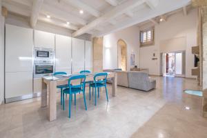 een keuken en een woonkamer met een tafel en stoelen bij Casa Scina' in Siracusa