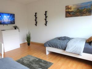 - une chambre avec un lit et une peinture murale dans l'établissement Helles Apartment mit Balkon für 5 Personen, à Schwerte