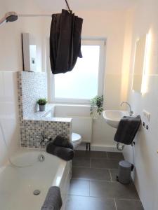 une salle de bain avec une baignoire, des toilettes et un lavabo dans l'établissement Helles Apartment mit Balkon für 5 Personen, à Schwerte