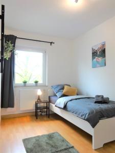 a bedroom with a bed and a window at Helles Apartment mit Balkon für 5 Personen in Schwerte