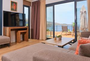 a living room with a couch and a tv at niXie Hotel & Beach - Adult Only in Yalıkavak