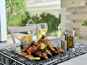 a table with a plate of food and a glass of wine at Opera Hotel in Nungwi