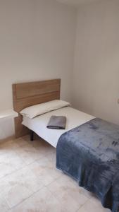 a bed with a wooden headboard in a room at La Quadra de Quelo 3 in Àger +12 photos