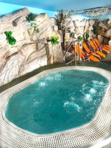 a pool in a resort with a rock wall at Apartma Bazilika in Topolšica