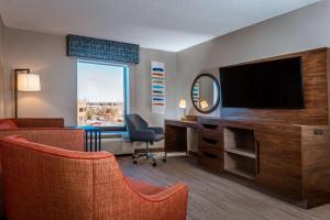 a hotel room with a desk with a tv and a mirror at Hampton Inn & Suites St. Louis-Chesterfield in Chesterfield