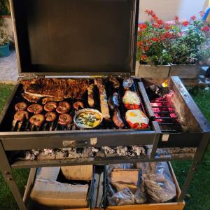 a grill with many different types of food on it at La Laguna - Casa familiar a 5 cuadras de la playa. in Puerto Madryn