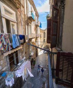 a man walking down a street with clothes drying on a clothes line at Naples Pizza Hostel in Naples