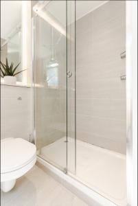 a bathroom with a shower and a toilet at Spacious and sunlit 3-bedroom apartment near Paddington Station in London