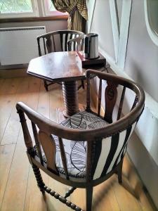 a wooden table and a chair with a coffee table and a tableablish at Chambres d'Hôtes Le Grismoustier in Veulettes-sur-Mer