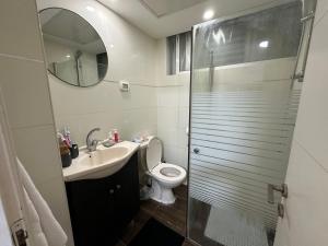 uma casa de banho com um lavatório, um WC e um espelho. em סוויטת אמור em Netanya