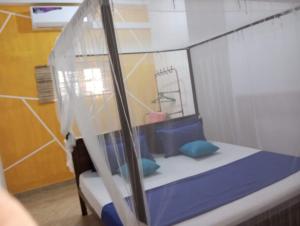 a bed with blue pillows in a room at freedom house in Unawatuna