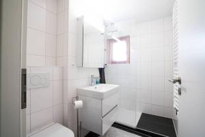 uma casa de banho branca com um WC e um lavatório em Fauvettes 110 em Verbier