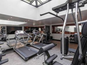 a gym with several treadmills and elliptical machines at Hôtel Paris Bastille Boutet - MGallery in Paris