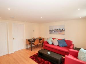 uma sala de estar com um sofá vermelho e uma mesa em Mellstock em Weymouth