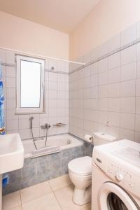 a white bathroom with a toilet and a sink at Cretan View Apartments with sea view in Stavros