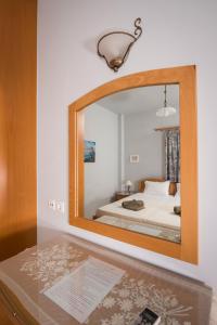 a mirror reflecting a bed in a bedroom at Cretan View Apartments with sea view in Stavros