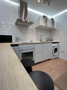 uma cozinha branca com um lavatório e uma máquina de lavar louça em Suite RR Fruela 641A em Oviedo