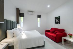 a bedroom with a bed and a red couch at Lark Pool Villa Aonang Krabi in Ao Nang Beach