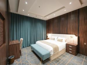 a bedroom with a large bed and a blue stool at شقق همس بارك للشقق المخدومة in Jeddah +67 photos