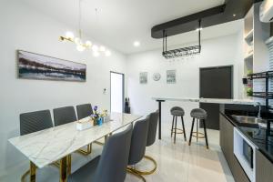 アオナンビーチにあるLark Pool Villa Aonang Krabiのキッチン、ダイニングルーム(大理石の大きなテーブル、椅子付)