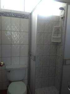 y baño pequeño con aseo y ducha. en Acojedor, en Lima
