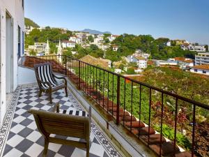 uma varanda com 2 cadeiras e vista para a cidade em Santa Teresa Hotel RJ - MGallery no Rio de Janeiro