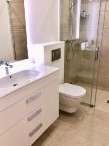 een badkamer met een wastafel, een toilet en een douche bij State of the Art Apartment in Magaluf