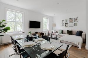 a living room with a table and a couch at Spacious and sunlit 3-bedroom apartment near Paddington Station in London