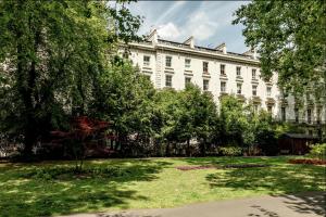 a large white building with a lawn in front of it at Spacious and sunlit 3-bedroom apartment near Paddington Station in London