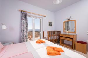 a bedroom with a bed and a desk and a window at Cretan View Apartments with sea view in Stavros