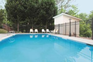 a swimming pool in a yard with a fence at La Quinta by Wyndham Covington in Covington