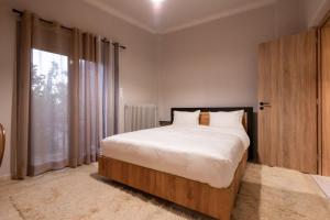 1 dormitorio con cama grande y ventana grande en STAMOS Apartment airport en Spáta