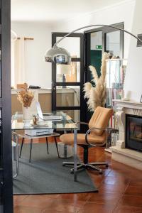 a living room with a glass table and a chair at Casa Idalia Boutique Hotel in Comporta