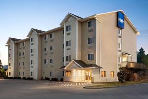 a large apartment building with a parking lot at Travelodge by Wyndham McAlester in McAlester