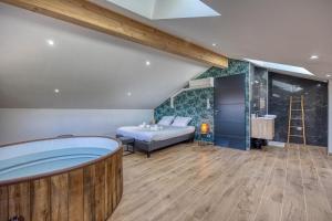 een kamer met een bad, een bed en een wastafel bij La Maison des Eymes - Jacuzzi / Coin Calme in Saint-Nazaire