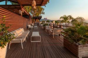 DoubleTree by Hilton Antalya-Kemer All-Inclusive Resort في كيمير: سطح السفينة به كراسي وكراسي على مبنى